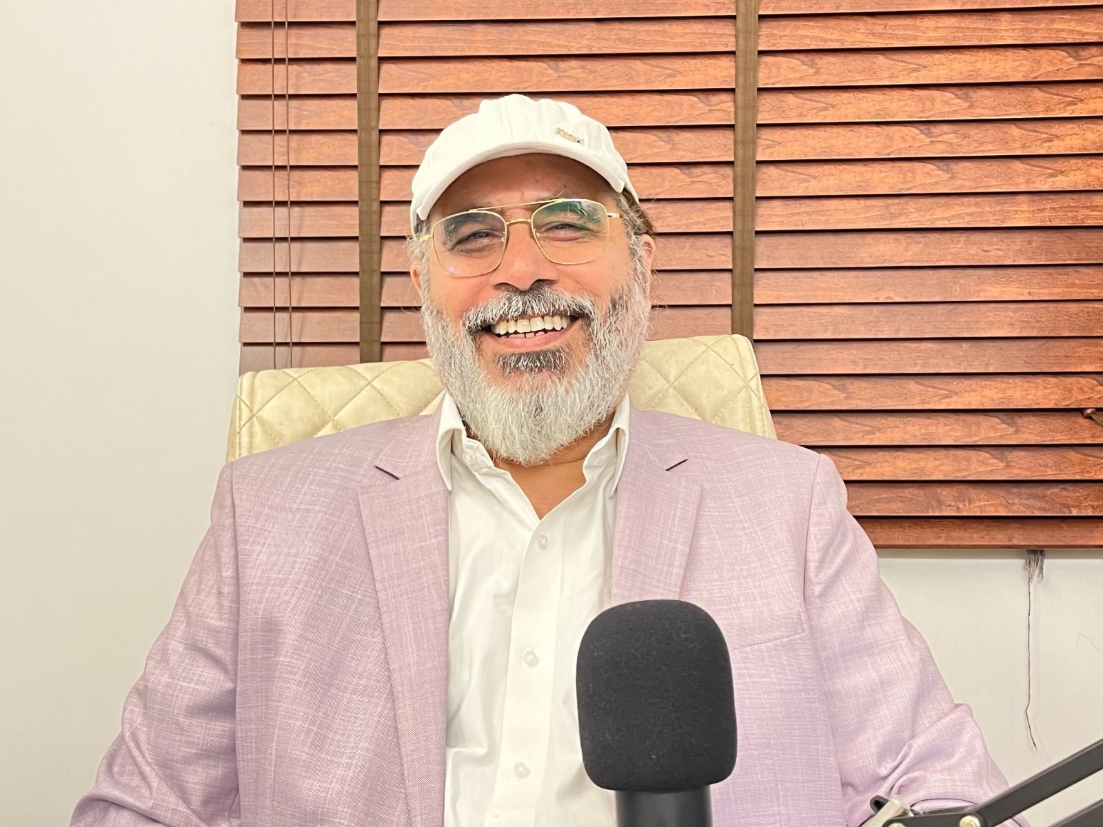 Manu Shandilya Ji seated indoors, speaking in conversation